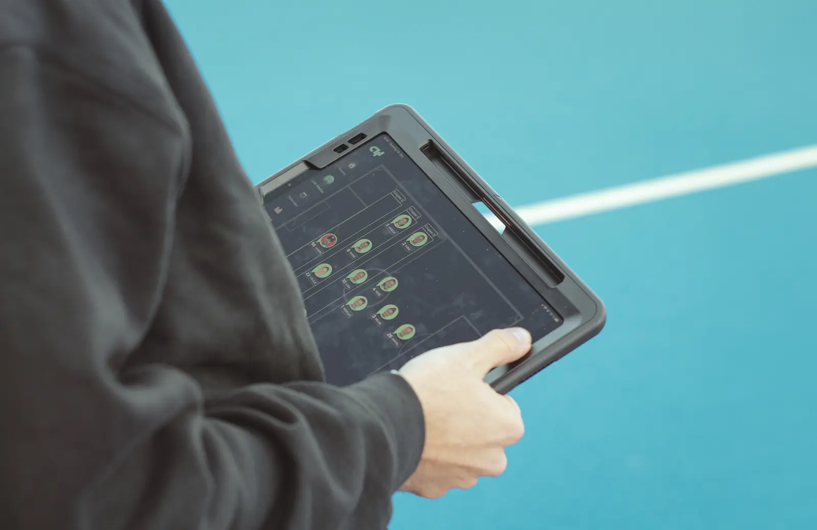 Coach holding an iPad with the Coach App from Coachwhisperer in their hands